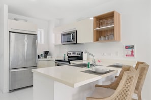 Cook with ease in a sleek, equipped kitchen featuring stainless steel appliances - Enjoy extra counter space & modern cabinetry for a seamless cooking experience - Whether preparing a quick snack or a gourmet meal, this kitchen has everything