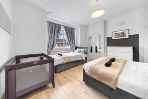 A lovely queen-sized bed with soft linens, providing a relaxing and comfortable space to rest. The room is spacious and thoughtfully designed.