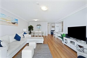 The open-plan living and dining area flows to the balcony, filling the space with natural light and fresh ocean breezes.
