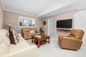 Unwind in the bright and airy open-concept living room, featuring plush seating, Smart TV, and direct access to the pool area. Perfect for movie nights or cozy conversations after a day of adventure!