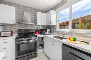 This fully equipped kitchen boasts high-end appliances, a spacious island, and all the essentials to prepare delicious meals. Gather around the dining table for a home-cooked feast in paradise!