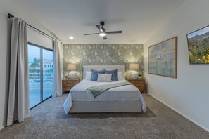 Upstairs primary suite has a king bed, TV, sitting area, walk-in closet, en suite bath and private balcony.