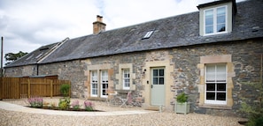 Stables Cottage - the entrance to the cottage with patio seating out the front