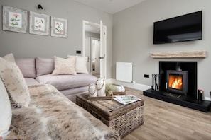 Honeysuckle Cottage - snuggle up on the comfortable corner sofa in front of the wood burning stove