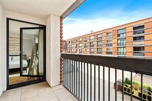 Relax on the private balcony with a stunning view of modern architecture. Perfect for morning coffee or evening relaxation. Enjoy the fresh air and open space.