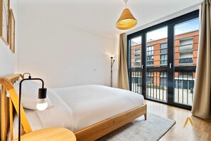 Bright and cozy bedroom with a comfortable bed and large windows. Enjoy a restful night's sleep and wake up to natural sunlight and a pleasant view.