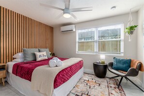 The bedroom is a cozy retreat featuring a comfortable queen mattress, a charming reading nook, and plenty of natural light that fills the space in the afternoon.