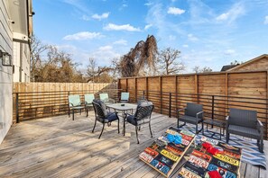 Private deck with a cornhole set, additional dining table that sits 4, and 2 seating areas. 