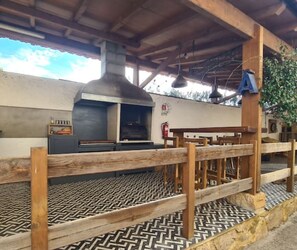 Shared outdoor kitchen, dining area and lounge. woodfired grill and oven.