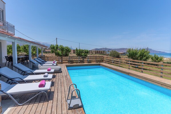 Pool area with luxurious sunbeds and sea views