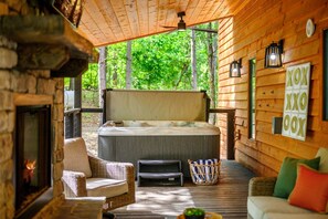Soak in total serenity beneath the pines. This private hot tub retreat is fully covered and steps from a fireplace lounge area.