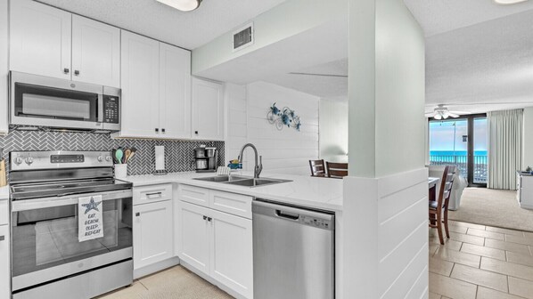 This fully equipped kitchen offers a fresh, modern vibe with crisp white cabinetry, sleek stainless steel appliances, and a stylish chevron tile backsplash. Whether you're prepping a seafood feast or blending morning smoothies, you'll find everything you 