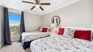 This bright guest bedroom features two cozy beds, cheerful bedding, and a large window that lets in natural light. It’s a comfortable and inviting space perfect for kids or extra guests.