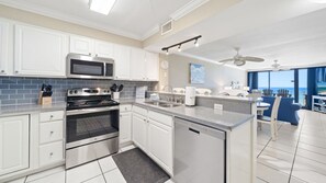 Fully equipped kitchen with view of the living and dining room. Stainless steel appliances.