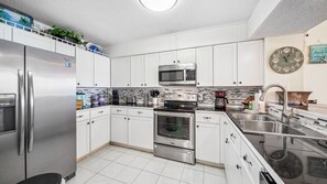 Fully equipped kitchen with stainless steel appliances.