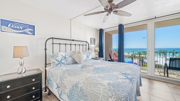 Main bedroom with king size, view of the pool, beach, and water.