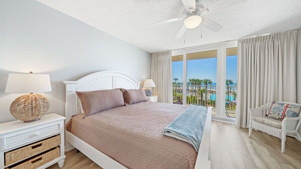 Serene Gulf-View Bedroom – Unwind in a plush king bed with soft coastal tones and direct access to balcony views of the palm-lined beach.