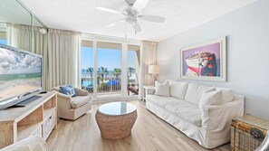 Bright & Breezy Living Room – Kick back in coastal comfort with a plush sofa, large TV, and balcony views just steps away.