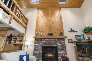 Living room with floor to ceiling windows, gas fireplace, RokuTV