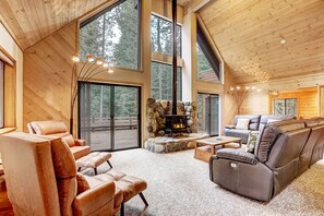 Living room with floor to ceiling windows, gas fireplace, and balcony access