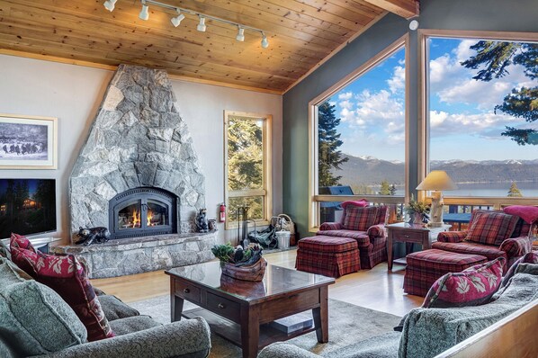 Cozy living room with a fireplace and stunning lake views through large windows