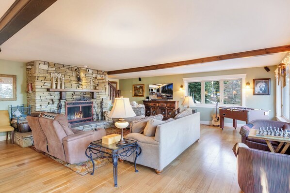 Mountain style living room with fireplace, smart TV and games