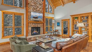 Spacious great room with gas fireplace, TV, and deck access