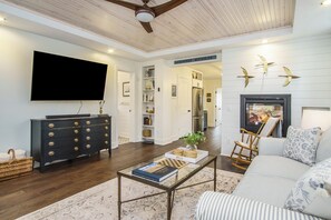 Living Room - Spacious and Brightly lit Living Room with mounted Smart TV and Gas Fireplace. View towards the Kitchen.