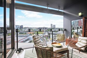 Settle in on the private balcony, featuring seating for four and a low wooden table—perfect for morning coffee, casual drinks, or sunset chats with a view.