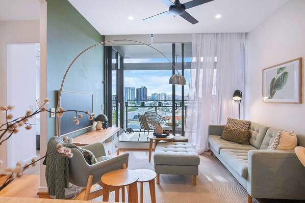 Lounge in style with sage-toned furnishings, a matching feature wall, and modern decor—bringing the urban charm of Newstead right into your home.