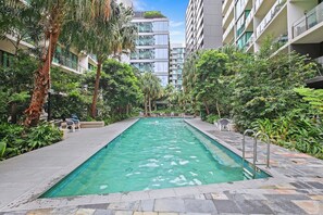 Dip into the sparkling shared pool surrounded by lush greenery—perfect for a refreshing escape from the Brisbane heat.