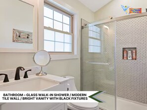 Modern bathroom featuring a walk-in shower, vanity sink, and lots natural light 
