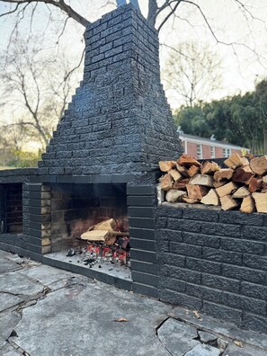 Original outdoor fireplace built in 1955 with outdoor dining tables for 8.