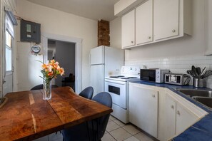 Rustic wood dining table adds charm to this bright, fully equipped kitchen.