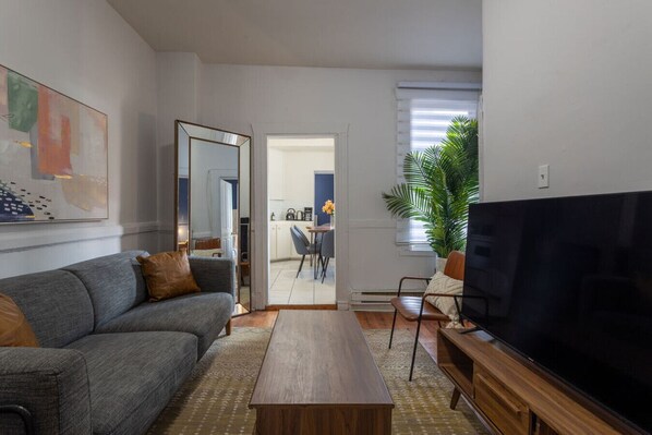 Contemporary lounge with cozy sofa, sleek TV, and natural lighting