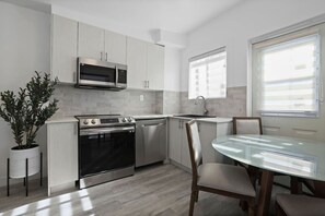 A fresh perspective on the open-concept cooking and dining space, flooded with natural light.