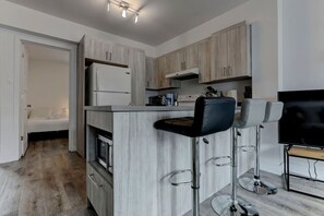 A sleek and functional kitchen with bar stools, ideal for casual dining or morning coffee.