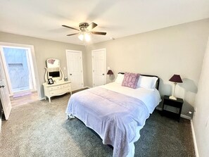 Spacious master bedroom featuring a queen bed with brand-new luxury linens and plenty of natural light for a peaceful night’s sleep