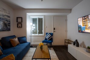 Chic living room with a stylish setup, cozy seating, and large window bringing in soft natural light.