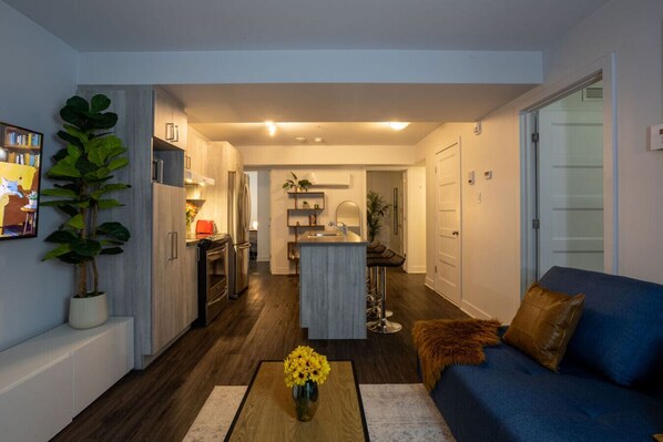 Bright and modern open-concept living space with a comfy couch, island kitchen, and inviting ambiance.