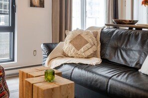 Living Room : Chic leather lounge and rustic wood accents for a warm, modern vibe.