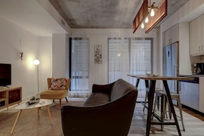 A beautifully designed open-concept living and dining area, highlighting stylish pendant lighting, rustic wooden accents, and a functional bar table.