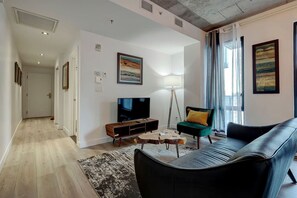 A welcoming space with a spacious layout, accent artwork, and floor-to-ceiling windows filling the room with natural light.
