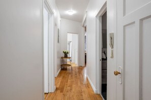 Clean hallway with warm wood floors and minimalist accents sets a welcoming tone