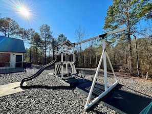Fun outdoor playground with swings and a slide, perfect for a family getaway.