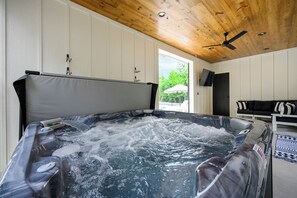Relax in a private hot tub with cozy seating, modern decor, and peaceful views.