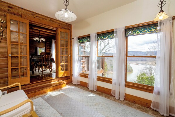 Bright and airy sunroom with panoramic views, cozy seating, and plenty of natural light—perfect for reading, relaxing, or taking in the scenery.