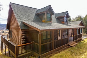 Cozy log cabin retreat with a charming wraparound porch, nestled amidst serene mountain views. Your perfect escape awaits!