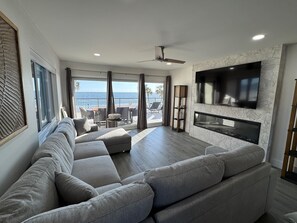 Living room with sleeper sectional, 75" flat screen TV and electric fireplace