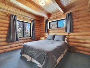 Primary bedroom with comfortable queen size bed and blackout curtains